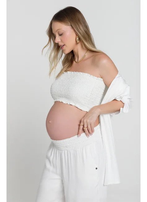 modelo de lado olhando pro chao com calca e camisa aberta branca e cropped lastex branco emma fiorezi