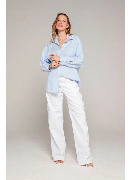 modelo com camisa azul e calca branca