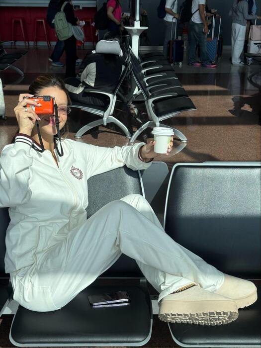 modelo com casaco e calca de moletom sport crema 101 off white segurando camera no olho