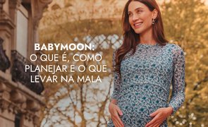modelo com vestido de manga longa com as duas maos na barriga e escrito babymoon o que e como planejar e o que levar na mala